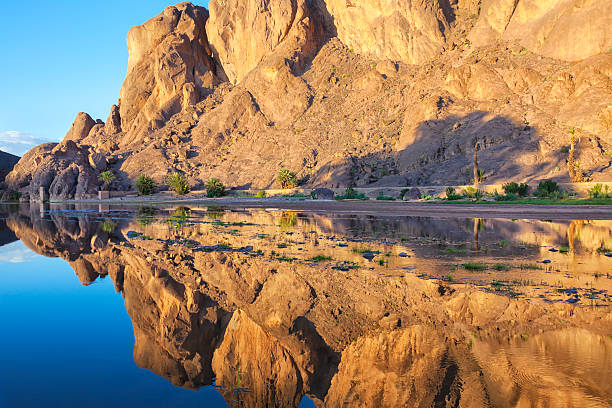 Mountain with reflections in a river, Fint Oasis. stock photo