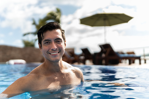Portrait of a mid adult man in the pool at hotel
