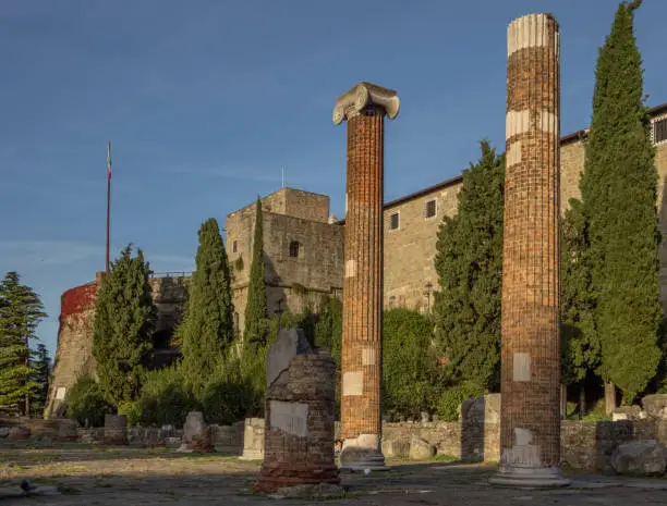 Photo of Ruins of the ancient Roman Forum and Basilica (1st century BC) with the medieval Castel San Giusto in the background. San Giusto Hill,Trieste, Friuli Venezia Giulia, northeast Italy