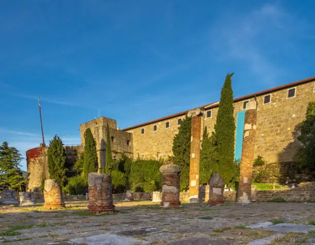 Photo of Ruins of the ancient Roman Forum and Basilica (1st century BC) with the medieval Castel San Giusto in the background. San Giusto Hill,Trieste, Friuli Venezia Giulia, northeast Italy