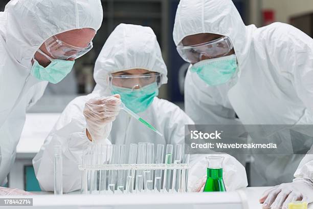 Chemist Adding Green Liquid To Test Tubes Stock Photo - Download Image Now - Medical Clinic, Research, Variation