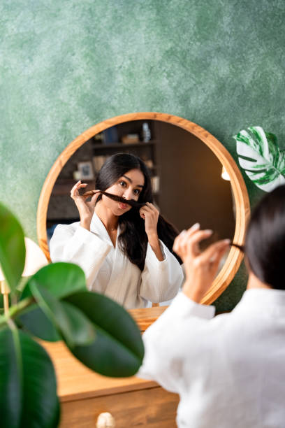 istock Funny woman spoils herself making a mustache looking in the mirror. 1784432643