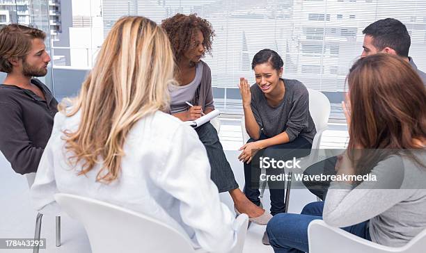 Woman Getting Depressed In Group Therapy Stock Photo - Download Image Now - Multiracial Group, Sadness, 20-29 Years