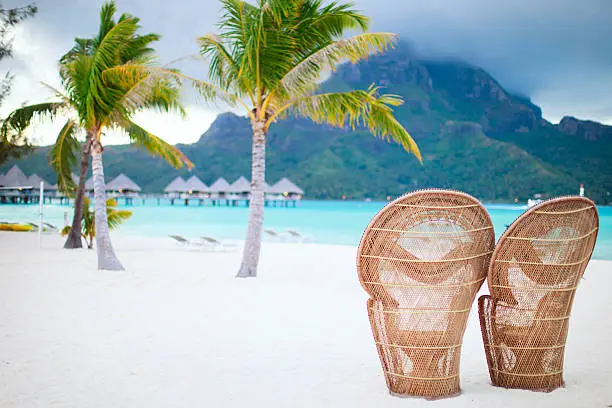 Two chairs on a beautiful beach of Bora Bora at evening