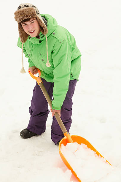 A young Chinese boy in the snow at sunset in the background