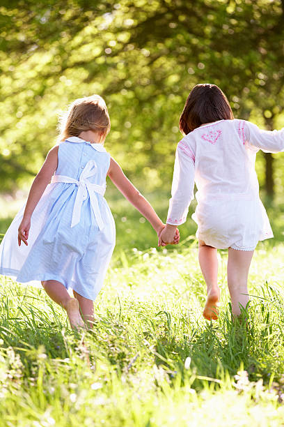 istock Two Young Girls Walking Through Summer Field Together 178443865