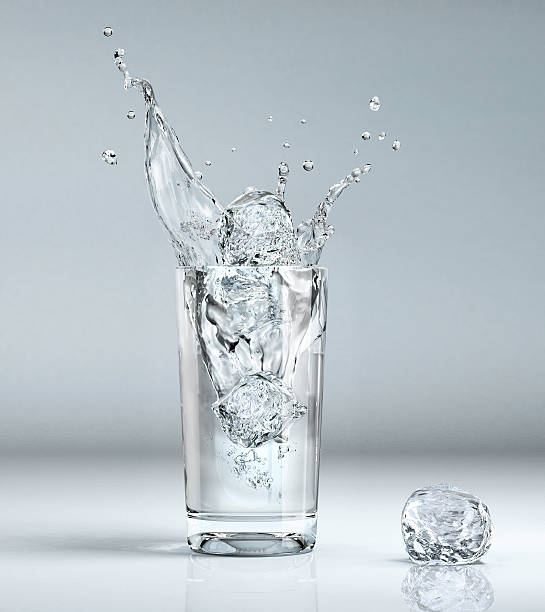 ice-cube jugando en un vaso con agua. - water flowing water pouring ice fotografías e imágenes de stock