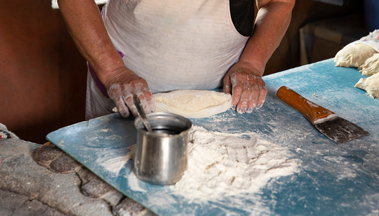 Woman's hands kneading a flour dumpling.