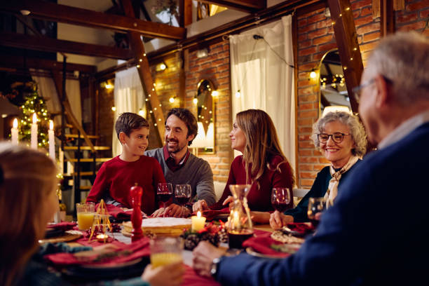 istock Happy extended family talking during Christmas dinner at dining table. 1784445697
