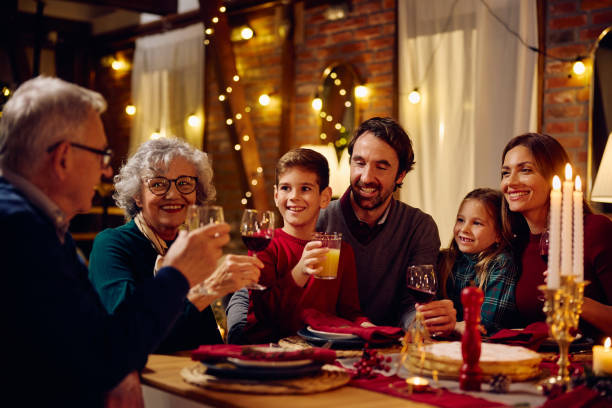 istock Happy multigeneration family toasting while gathering for dinner at Christmas. 1784445756