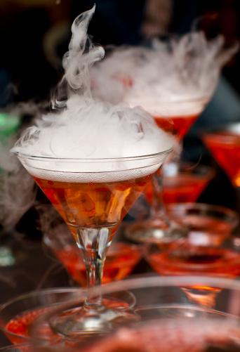 Pyramid of smoking molecular cocktails.Champagne with red caviar, made ​​from orange juice.