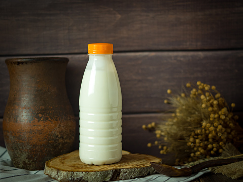 milk in a plastic bottle on a rustic background, minimalism, copy space