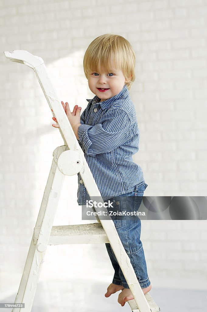 Mały chłopiec stojący na krok drabiny Metaliczny - Zbiór zdjęć royalty-free (Aspiracje)