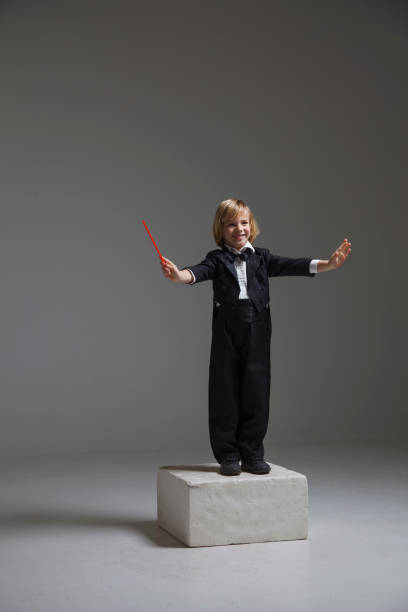 Side view portrait of little boy wearing costume peeking over curtain backstage in theater copy space
