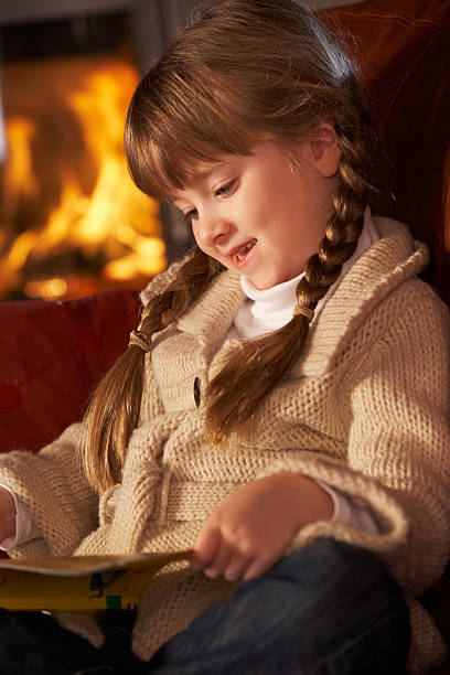 istock Young Girl Sitting On Sofa And Reading Book 178447562