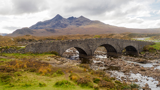 The Old Bridge at Sligachan on the Isle of Skye, Scotland, with the mountains of the Black Cuillin in the background.