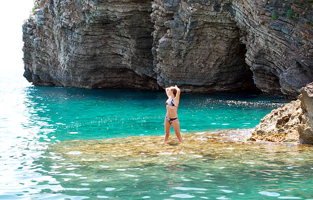 istock Woman sunbathes on a rock 178449608