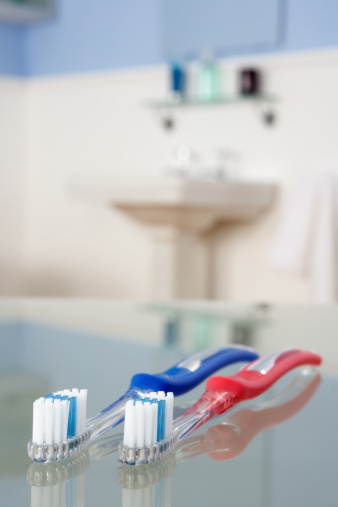 Toothbrushes in bathroom On Glass Top