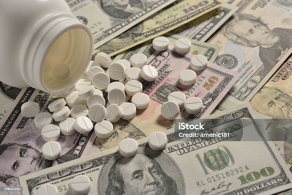 pills white round medicine tablets on money Bottle Stock Photo