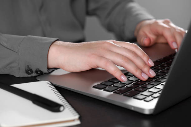 istock Woman typing on laptop at table, closeup. Electronic document management 1784517573