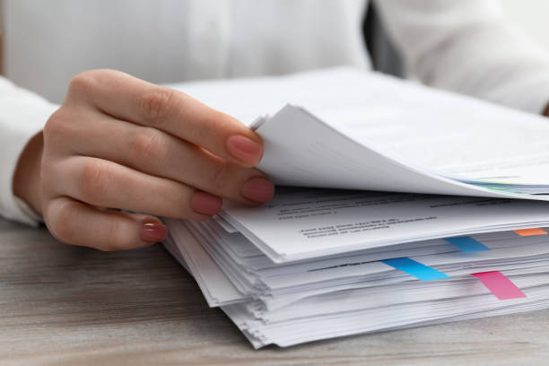 istock Woman reading documents at wooden table in office, closeup 1784518362