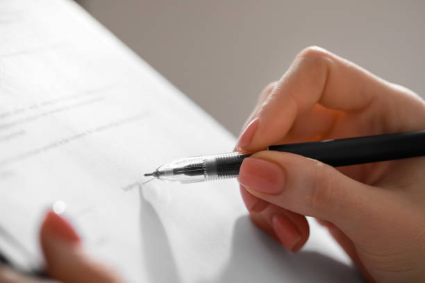istock Woman signing documents on light gray background, closeup 1784518924