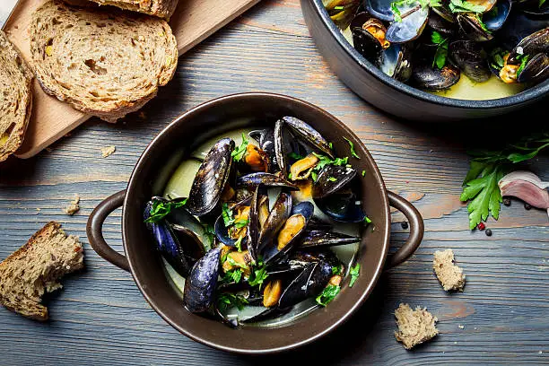 Closeup of mussels served with bread in a country way.