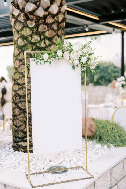 istock Empty sign on a stand decorated with white flowers stands near a palm tree 1784523828
