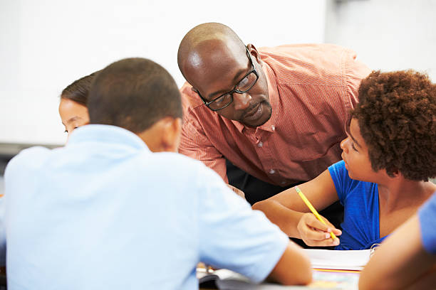 istock A teacher helping students studying at their desks in class 178452417
