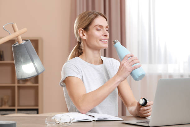 istock Woman with thermo bottle at workplace in room 1784529257