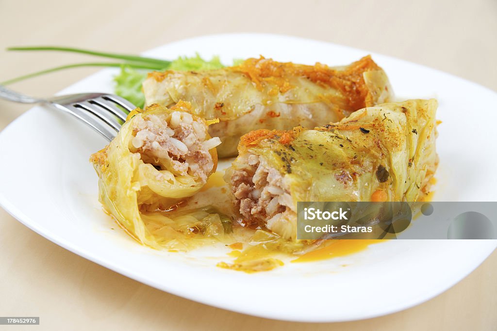 Cabbage Rolls Baked cabbage rolls with carrots and rice with a tomato sauce on white plate. Broad Bean Stock Photo