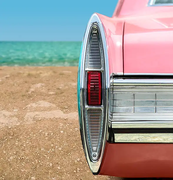 Vintage pink car tail light detail on the beach