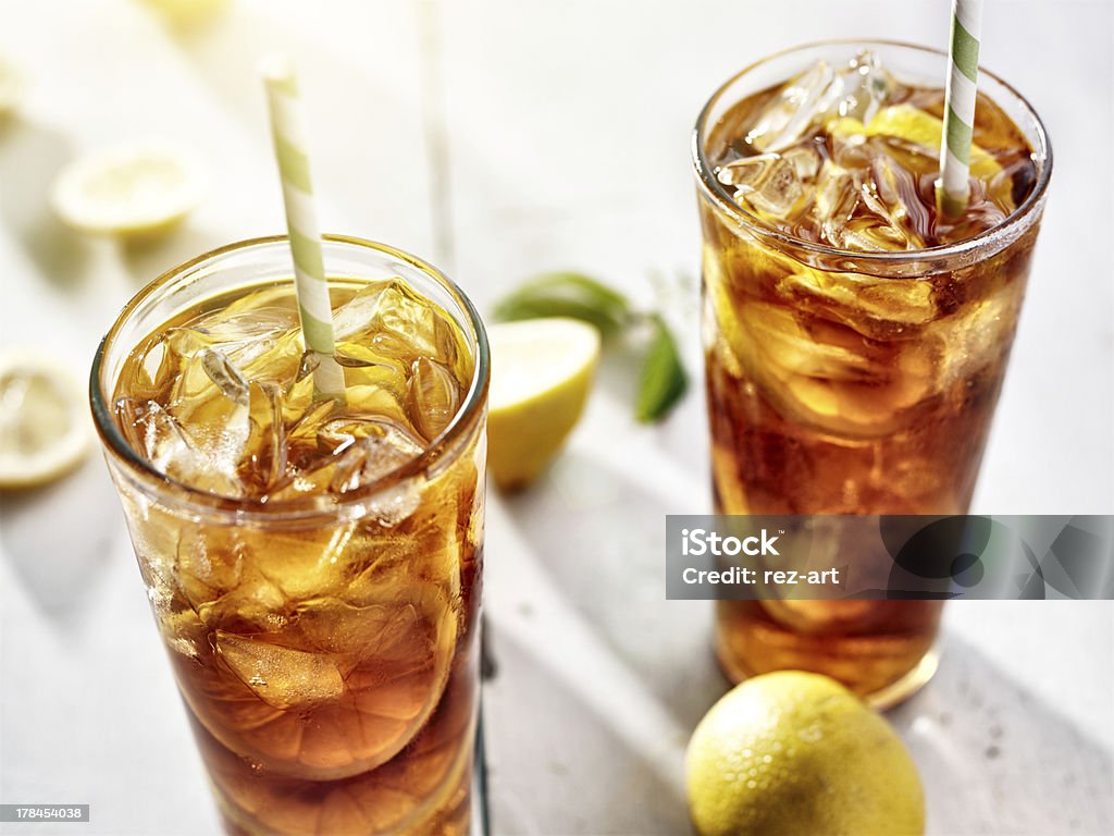 two ice cold glasses of iced tea with lemons close up photo of two cold glasses of iced tea with lemons. Shot with selective focus. Ice Tea Stock Photo