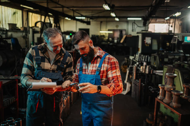 istock Two engineers measuring and noting data about a metal piece in a factory. 1784540508