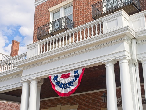 Lenox, Massachusetts - USA, October 26, 2023. American flag bunting hangs over porch on historic Curtis hotel building in Lenox Massachusetts.