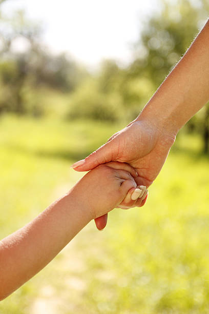 istock parent holds the hand of a child 178454620