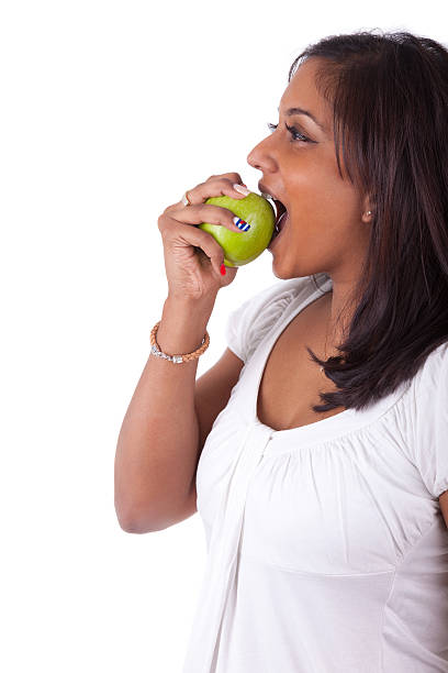 istock Young indian woman eating an apple 178454727