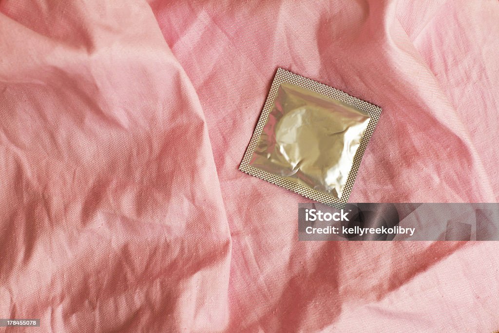 Kondom auf Faltig der pink bedsheet - Lizenzfrei Bettbezug Stock-Foto