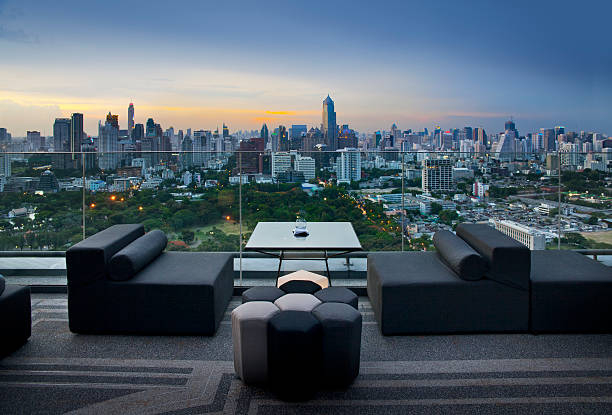 Sofa on terrace overlooking green park and building, Bangkok, Thailand stock photo