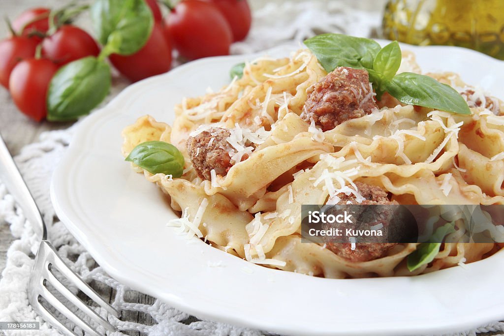 Reginette with meatballs Italian pasta Reginette or Mafaldine with tomatoe sauce and meatballs, decorated with basil and grated parmesan cheese Basil Stock Photo