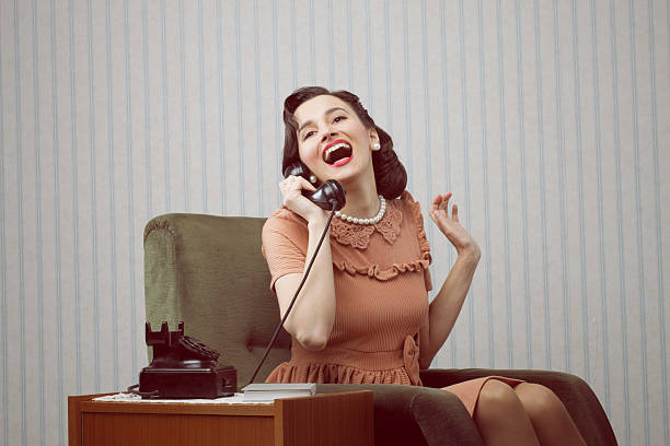 固定電話で話している陽気女性 - ダイヤル式電話 ストックフォトと画像