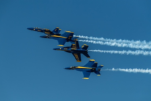 San Francisco, United States – October 07, 2023: Five sleek jet airplanes flying in formation, leaving long contrails in the bright blue sky