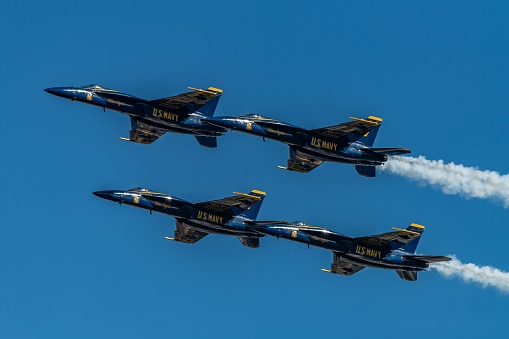 San Francisco, United States – October 07, 2023: Four fighter jets flying in formation with a white smoke trail behind them, creating a dramatic and powerful display in the sky