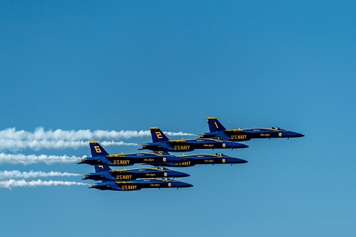 San Francisco, United States – October 07, 2023: A formation of five fighter jets flying in unison against a clear blue sky background