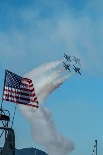 San Francisco, United States – October 07, 2023: Two military aircraft flying in formation over a boat with an American flag, symbolizing patriotism