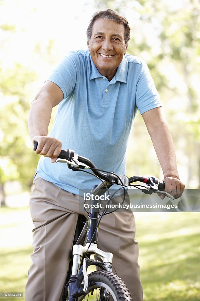 Senior Hispanic man riding bike Senior Hispanic man riding bike outdoors having fun Senior Adult Stock Photo