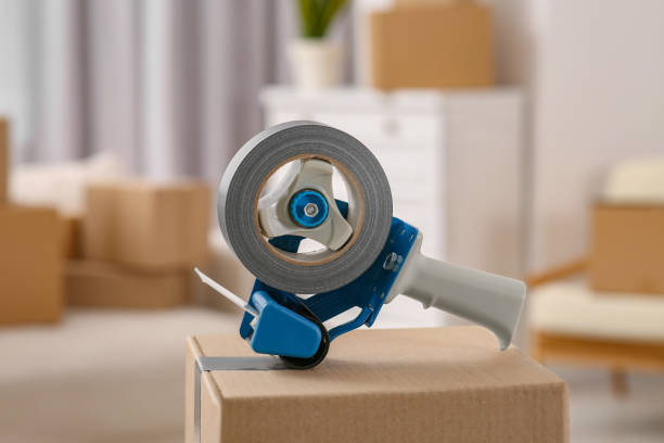 istock Dispenser with roll of adhesive tape on box indoors 1784591200