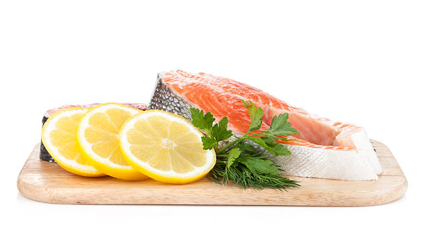 istock Salmon steaks on cutting board with lemons and herbs 178459286