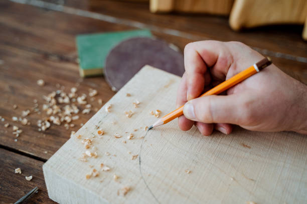 istock The carpenter draws with a pencil on the board. hand holds a pencil, carpentry workshop, sketch of the future product 1784592865