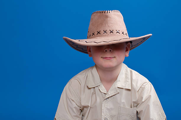 portrait of a boy in a cowboy hat on a blue backgroundportrait of a boy in a cowboy hat on a black background